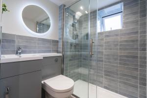 a bathroom with a toilet and a glass shower at Griffin's Rest - Parking, Countryside views in Newquay