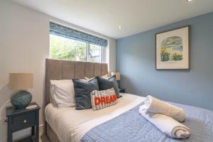 a bedroom with a bed with blue walls and a window at Griffin's Rest - Parking, Countryside views in Newquay