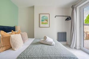a bedroom with a bed with pillows and a window at Griffin's Rest - Parking, Countryside views in Newquay
