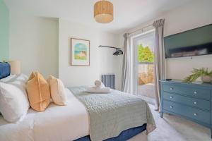 a bedroom with a bed with a blue dresser and a window at Griffin's Rest - Parking, Countryside views in Newquay