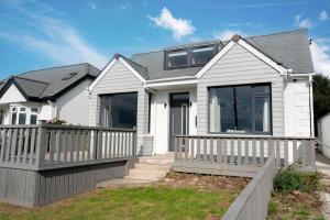 a white house with a porch and balcony at Griffin's Rest - Parking, Countryside views in Newquay
