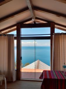 a room with a large window with a view of the ocean at Casa Andina - ISLA DEL SOL in Comunidad Yumani