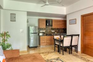 a kitchen with a table and a refrigerator at Graceful 1BHK Apartment by tisyastays in Candolim