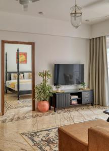 a living room with a tv and a bed at Graceful 1BHK Apartment by tisyastays in Candolim