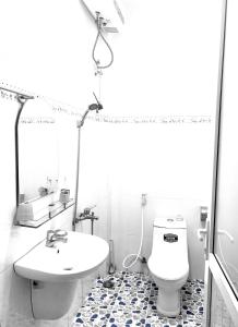une salle de bain avec un lavabo, des toilettes et un miroir dans l'établissement Hiên Cúc Vàng Homestay, à Da Thanh