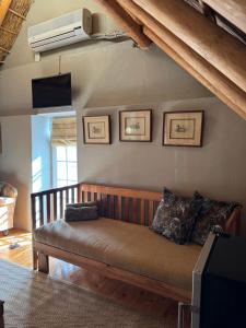 a living room with a couch and a tv at Port Wine Guesthouse in Calitzdorp