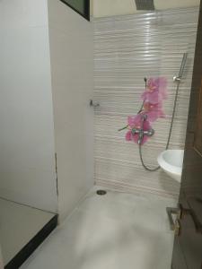a bathroom with a sink and a pink flower on the wall at Satyabhama Homestay-Pearl - Two BHK Luxury appartment in Indore +5 photos