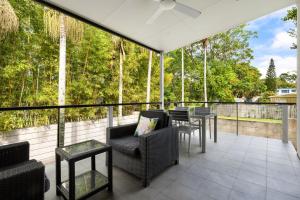 a patio with chairs and tables on a balcony at Lane by the Bay - Centrally located 2 bed modern Townhouse in Byron Bay