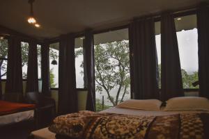 a bedroom with a bed in front of a window at Hostel Hideout in Bhīm Tāl