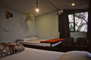 a room with two beds and a window at Hostel Hideout in Bhīm Tāl +55 photos