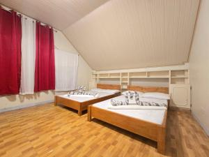 two beds in a room with red curtains at 35 Amistad Guesthouse in Baguio