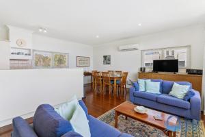 a living room with two blue couches and a table at Mandurah Overlooking The Marina in Mandurah
