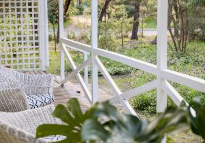 a porch with two wicker chairs and a fence at Poppy's Place - Denmark in Denmark