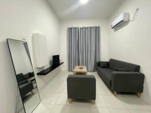 a living room with a couch and a chair at Anderson 2 room Ipoh city center in Ipoh
