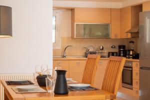 a kitchen with a wooden table with glasses of wine at Ormos Sea View Apartment in Agios Nikolaos
