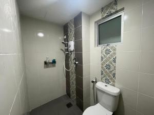 a bathroom with a toilet and a television on the wall at Anderson 2 room Ipoh city center in Ipoh