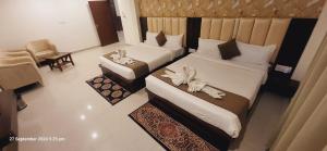 AyodhyaNeelkanth Hotel的酒店客房,配有两张带鲜花的床