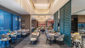 un comedor con mesas y sillas en Holiday Inn Wuhan Houguan Lake by IHG, en Wuhan