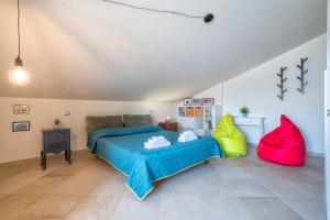 een slaapkamer met een blauw bed en een rode stoel bij Non dire Gatto - Elegant Rooftop in Alghero