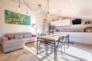 een keuken en woonkamer met een tafel en een bank bij Non dire Gatto - Elegant Rooftop in Alghero