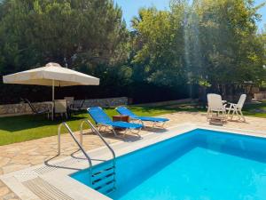 a swimming pool with chairs and an umbrella at Evilion Ktima Argyropoulou in Katarrákhion