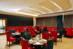 a dining room with tables and red chairs at Park Regency Kapurthala in Kapūrthala