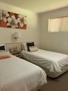 a bedroom with two beds and a window at Casa Palma in Palm Cove