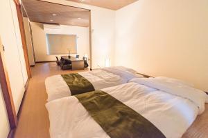 a bedroom with two beds in a room at Bijou Suites Ten in Osaka