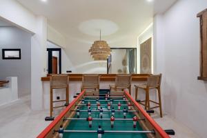 a room with a foosball table and chairs at Villa Kleoa - Luxury 4 Bedrooms Villa Walking Distance to Seseh Beach in Canggu