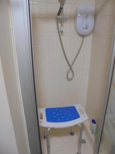 a shower with a blue stool in a bathroom at 3 Station Court, Munlochy in Munlochy