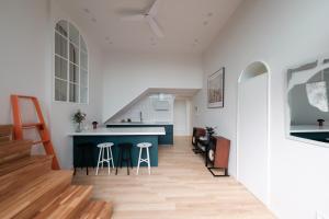a kitchen and living room with a blue counter and stools at Blik Stille Hyochang 101 Yongsan Premium House in Seoul