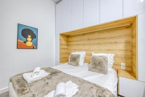 a bedroom with a large bed with a wooden headboard at Studio Cosy Bordeaux Centre in Bordeaux