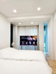 a bedroom with a large bed with a flat screen tv at Blik Stille Hyochang 101 Yongsan Premium House in Seoul