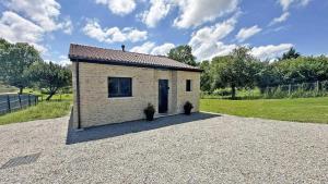 ein kleines Backsteingebäude auf einem Schottergrundstück in der Unterkunft La maison neuve in Veyrac