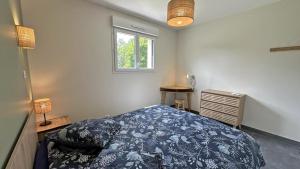 ein Schlafzimmer mit einem Bett und einem Fenster in der Unterkunft La maison neuve in Veyrac