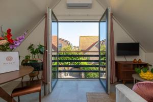 a living room with a sliding glass door leading to a balcony at Welcome in - Appartement Bed by Al - Achterstraat 9 Kortgene in Kortgene