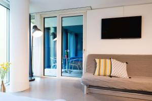 a living room with a couch and a flat screen tv at HITrental Allmend Comfort Studios in Lucerne