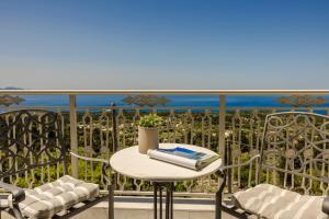 a table on a balcony with a view of the ocean at Belle View Hotel - Sea View & Sunset in Mánganos