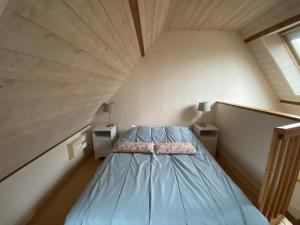 a bedroom with a blue bed in an attic at Studio charmant à 70m des Thermes, WiFi, Animaux bienvenus - FR-1-541-137 in La Roche-Posay +2 photos