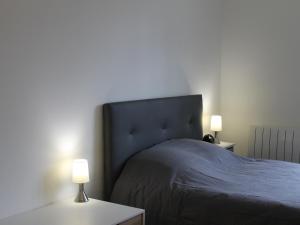 a bedroom with a bed with two tables and two lamps at T2 lumineux centre-ville avec Wi-Fi, lave-linge et lave-vaisselle - FR-1-541-122 in La Roche-Posay +2 photos