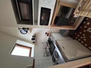 - une vue de tête sur une cuisine équipée d'un évier et d'un four micro-ondes dans l'établissement Studio cosy en centre-ville, proche Thermes - FR-1-541-135, à La Roche-Posay