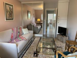 a living room with a couch and a glass table at Appartement tout confort avec WIFI, lave-linge et lave-vaisselle - FR-1-541-136 in La Roche-Posay