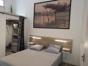 ein Schlafzimmer mit einem Bett mit einem Bild an der Wand in der Unterkunft Maison rénovée avec cuisine équipée à La Roche-Posay - FR-1-541-148 in La Roche-Posay