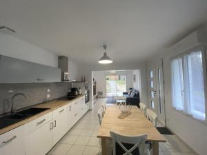 eine Küche mit Holztisch und ein Esszimmer in der Unterkunft Maison rénovée avec cuisine équipée à La Roche-Posay - FR-1-541-148 in La Roche-Posay