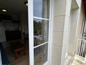 a sliding glass door with a view of a room at T2 avec piscine et WiFi à 200m des Thermes - FR-1-541-150 in La Roche-Posay