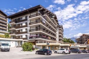 Un edificio con coches aparcados en un estacionamiento. en Valaisia 17B - 4 pers - centre station, en Nendaz