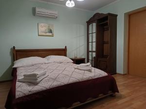 a bedroom with a bed with two towels on it at Вілла Токай in Rakhiv