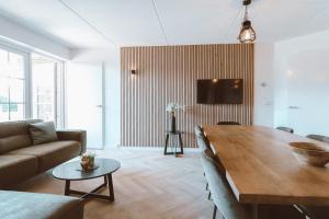 a living room with a table and a couch at Grijze Veen 8-person bungalow in Voorthuizen