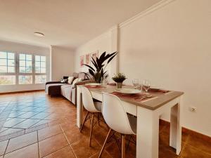 Un comedor con una mesa y un sofá. en Click&Guest - Atlantic Sun House in Playa Arinaga, en Agüimes