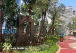 a building with palm trees next to a sidewalk at 2 Bed Casa Grande Mall Kota Kasablanka By Travelibu in Jakarta